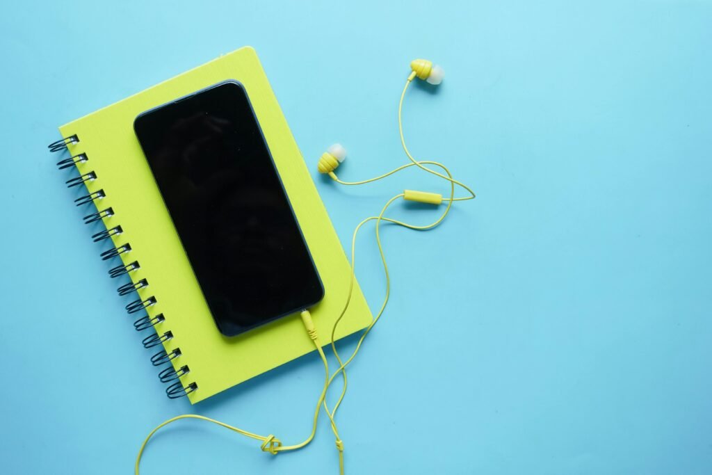 pexels-photo-11743793-11743793 Colorful flat lay of a smartphone, notebook, and earbuds on a blue background. Perfect for tech and lifestyle themes.